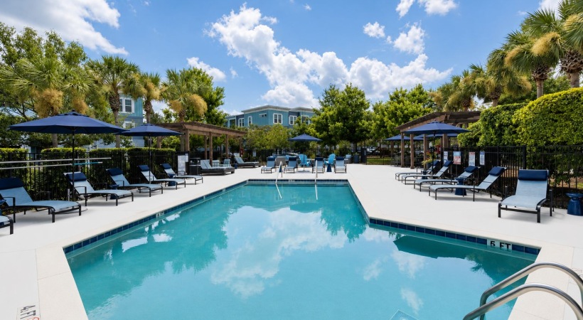 a pool with chairs and umbrellas by it