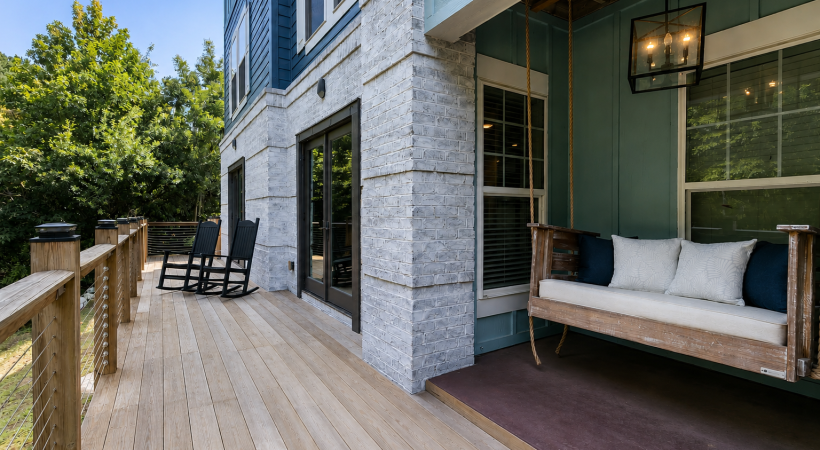 A deck with chairs and tables on it with trees in the background at Parker Point apartments for rent in Charleston. 