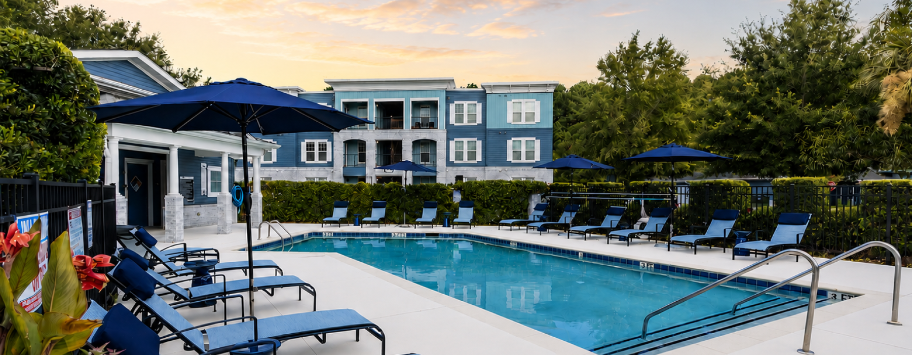 A pool with lounge chairs, umbrellas, and a wooden pavilion at Parker Point Charleston, SC rentals.