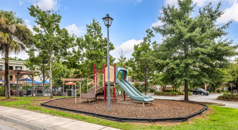 a playground with trees and a lamp post