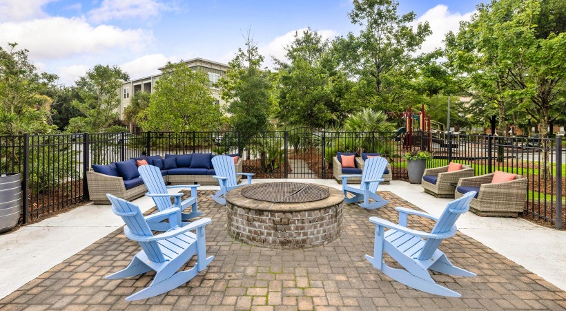 a patio with chairs and a fire pit